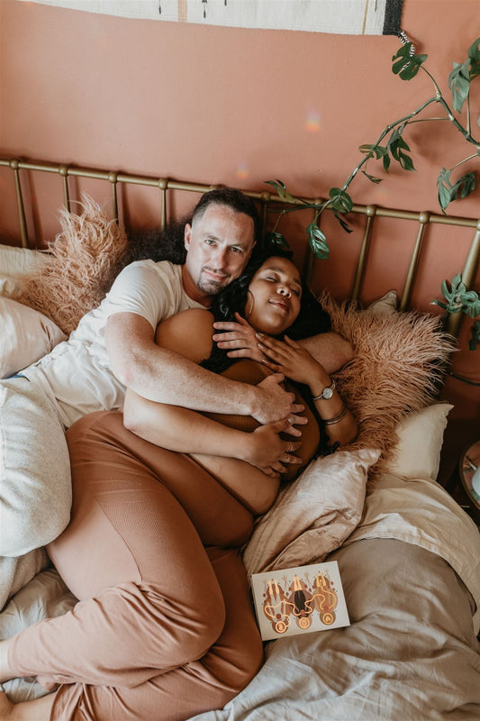 couple cuddling in bed with game